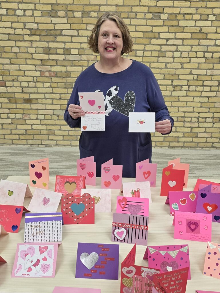 Woman volunteering in the Twin Cities hand making cards for older adults with Friends & Co