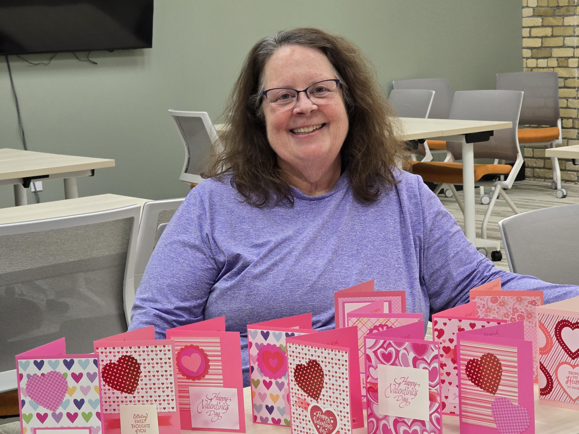 Woman smiling while hand making cards with Friends & Co volunteering