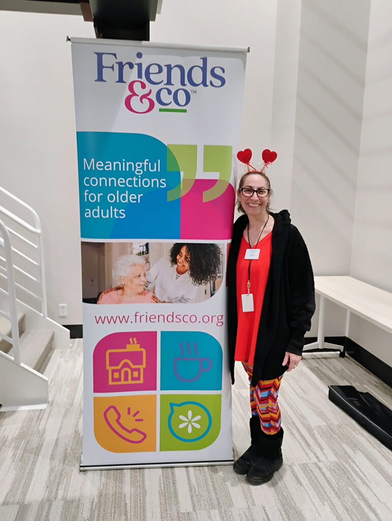 Jethra Kapp standing next to the Friends & Co banner