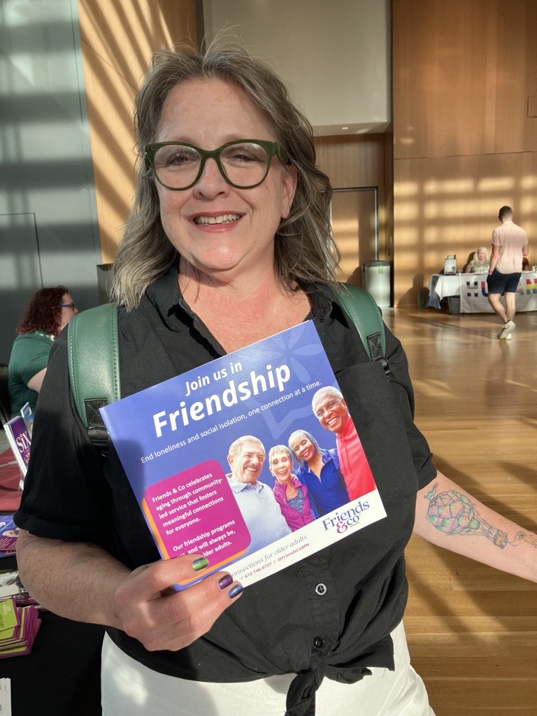 Woman at orchestra hall holding Friends & Co infomation packet