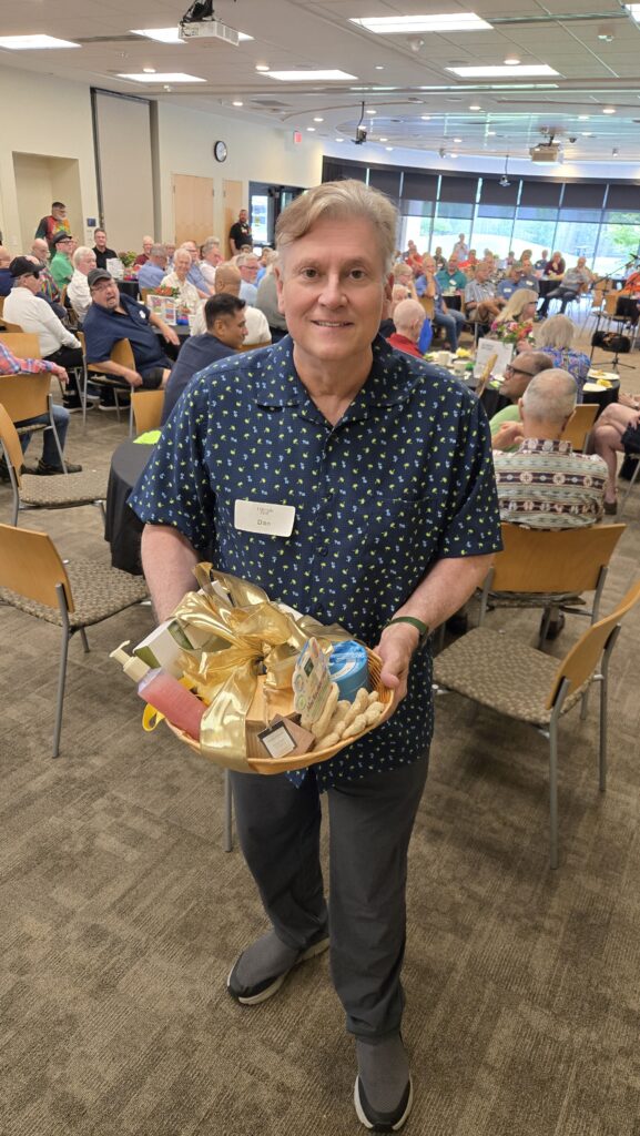 Man Older adult holding his winning themed gift basket